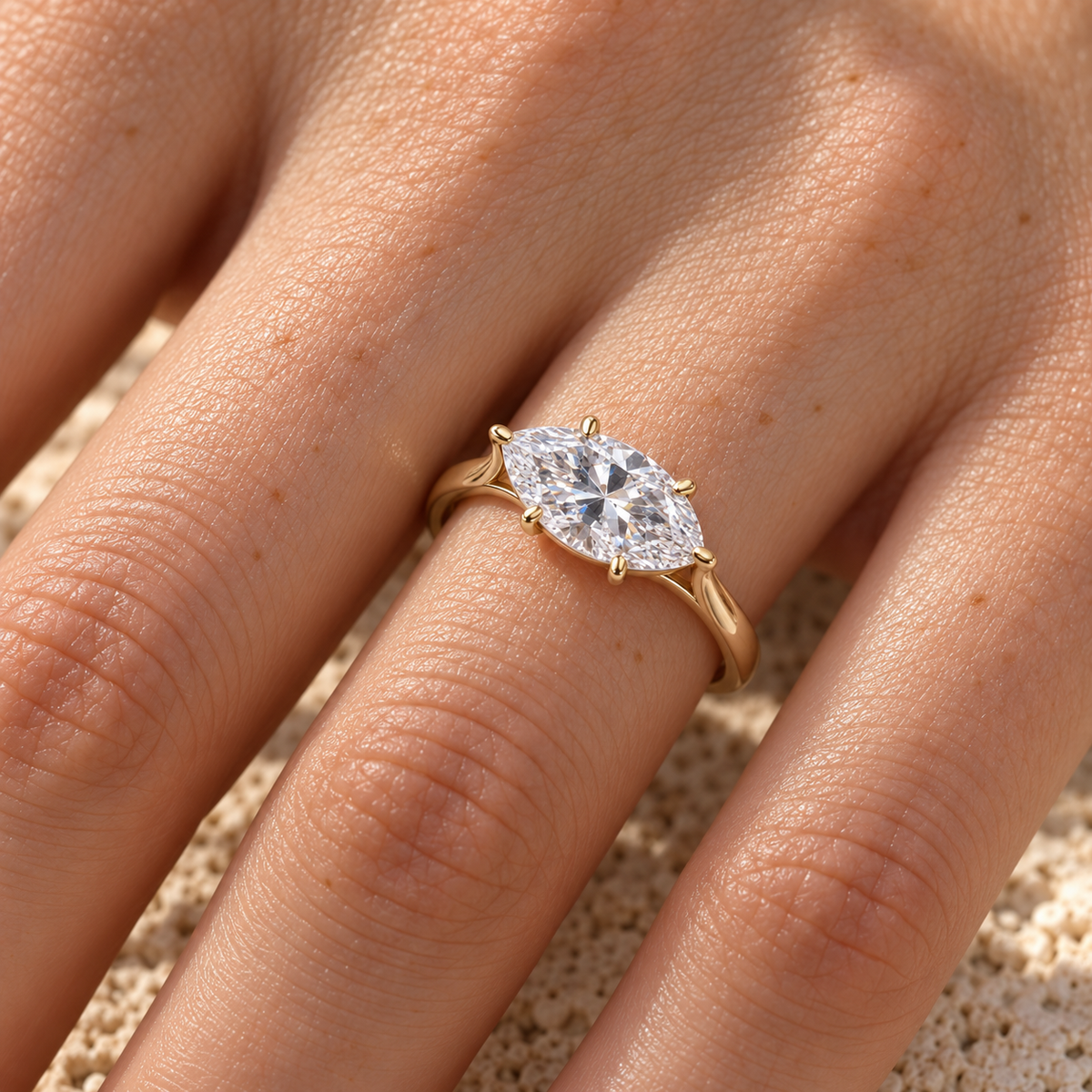 East-west marquise moissanite solitaire ring in yellow gold worn on the hand
