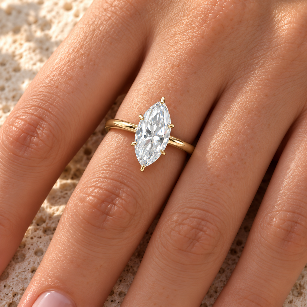 Marquise moissanite solitaire ring in yellow gold worn on the hand