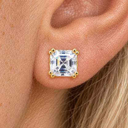 Asscher cut moissanite stud earring in yellow gold worn on the ear