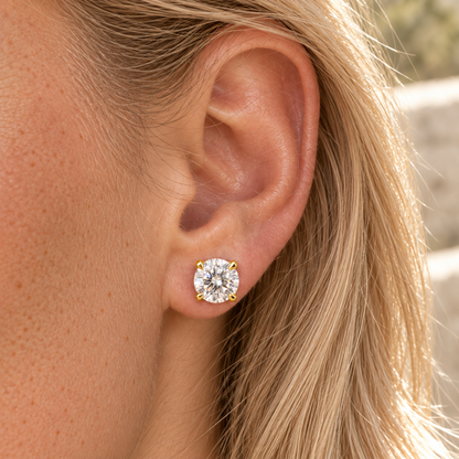 Round moissanite stud earring in yellow gold worn on the ear