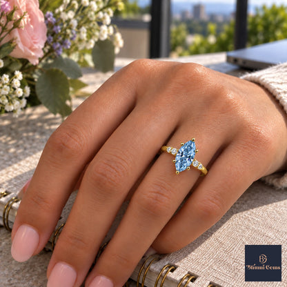 Blue Marquise Cut Lab Grown Diamond Engagement Ring - Round Accents in yellow gold, worn on the hand