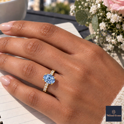 Blue Oval Cut Lab Grown Diamond Engagement Ring - Cathedral Pave Band in yellow gold, worn on the hand