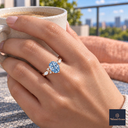 Blue Oval Cut Lab Grown Diamond Engagement Ring - Leaf Cluster Shoulders in rose gold, on the hand