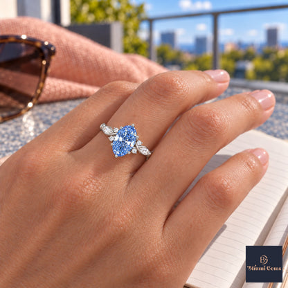Blue Oval Cut Lab Grown Diamond Engagement Ring - Leaf Cluster Shoulders in white gold, worn on the hand