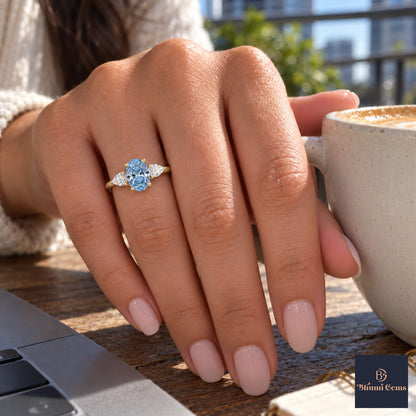 Blue Oval Cut Lab Grown Diamond Engagement Ring - Pear Side Stones in yellow gold, on the hand