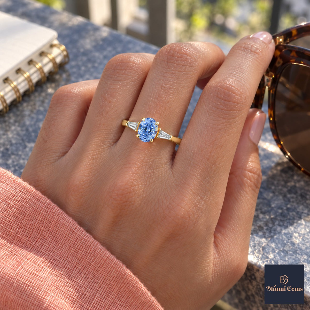 Blue Oval Cut Lab Grown Diamond Engagement Ring - Tapered Baguettes in yellow gold, worn on the hand