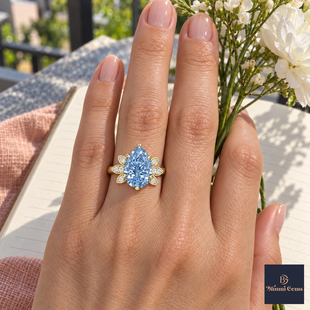 Blue Pear Cut Lab Grown Diamond Engagement Ring - Floral Leaf Accents in yellow gold, worn on the hand