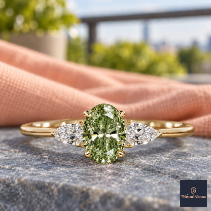 Green Oval Cut Lab Grown Diamond Engagement Ring - Pear Side Stones in yellow gold, close-up