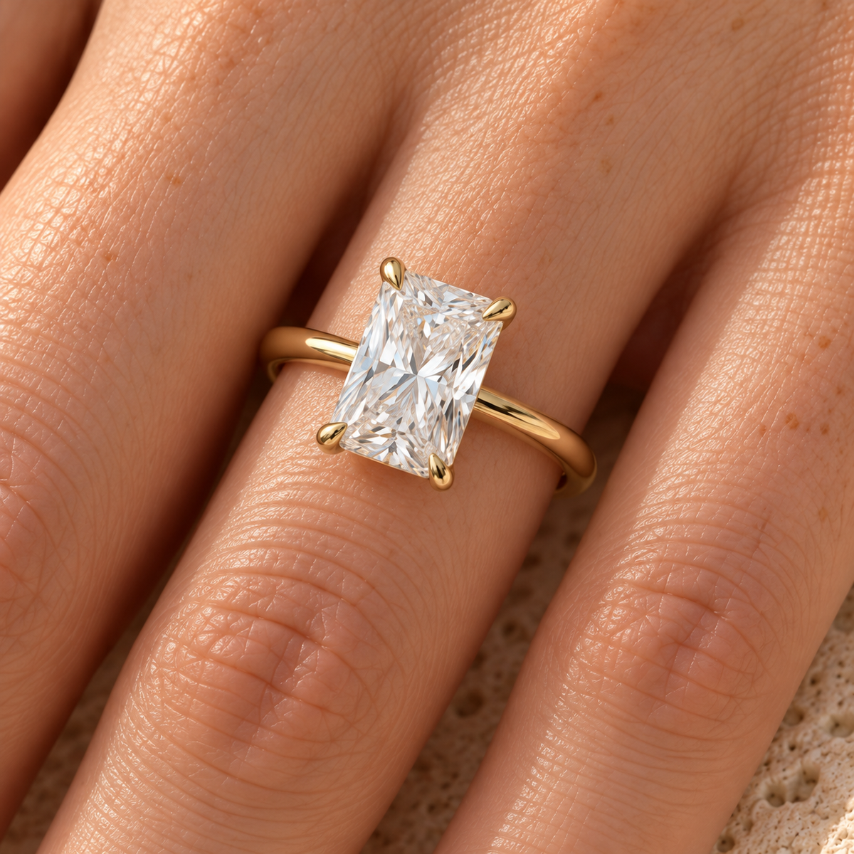 Radiant lab grown diamond hidden halo thin band ring worn on hand, yellow gold