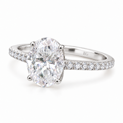 Oval moissanite engagement ring with four prongs and pave band in white gold