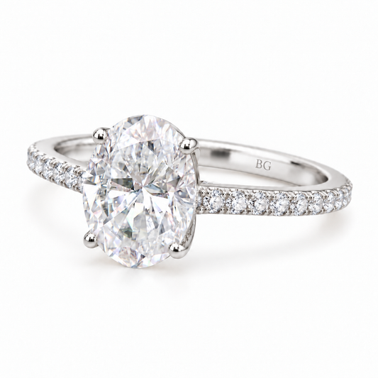 Oval moissanite engagement ring with four prongs and pave band in white gold