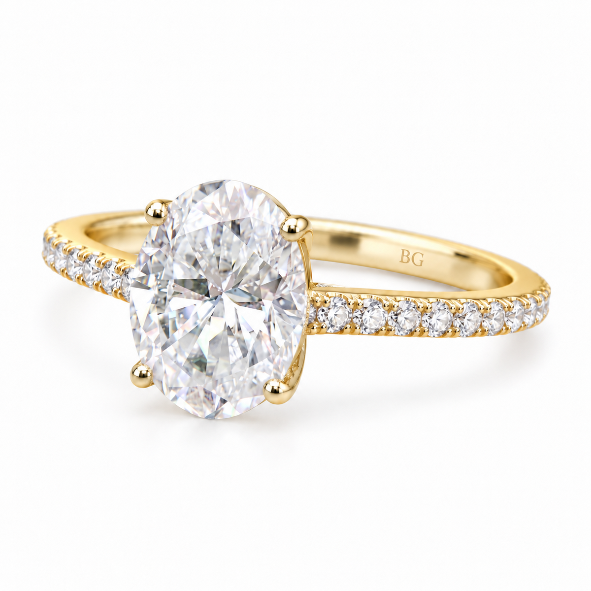 Oval moissanite engagement ring with four prongs and pave band in yellow gold