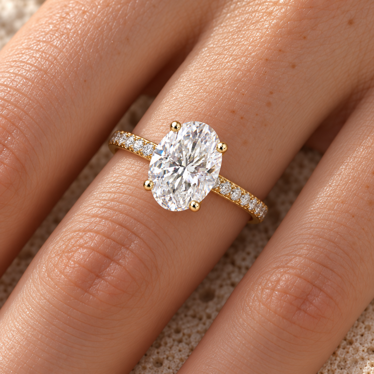 Oval moissanite pave engagement ring in yellow gold worn on the hand